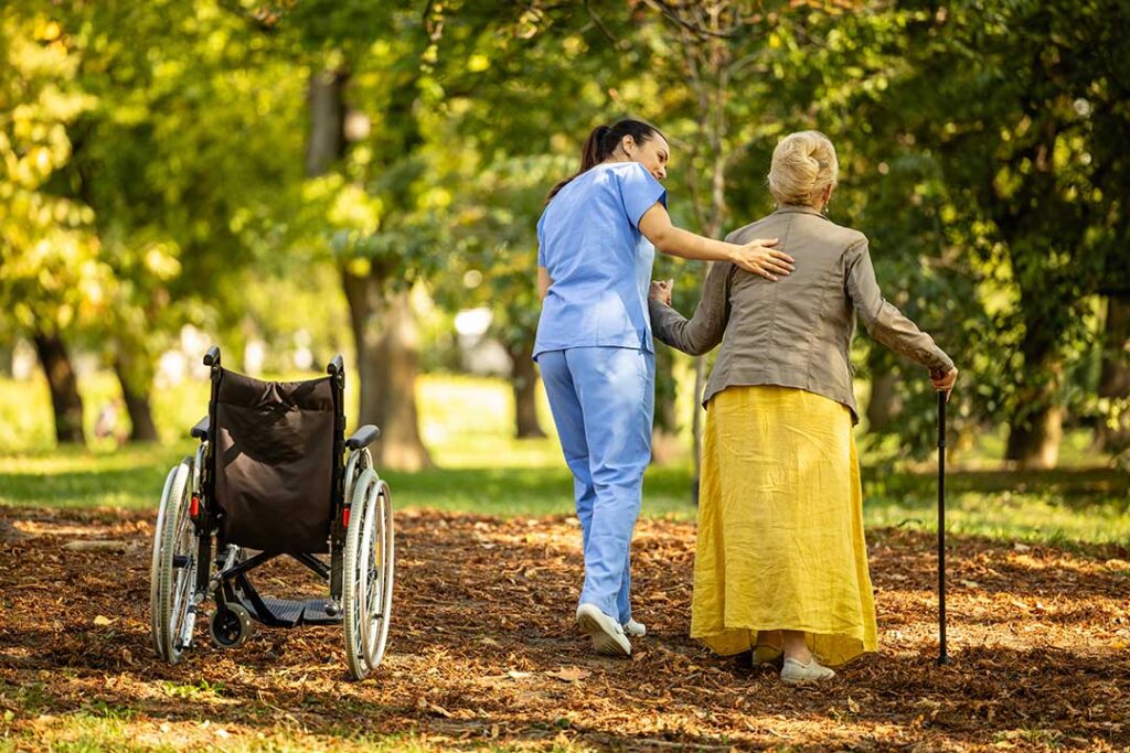 Family member and older resident review care notes together at a kitchen table.